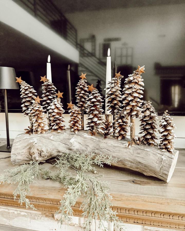 Rustic pinecone Christmas tree centerpiece on driftwood from @thepondsfarmhouse showing elegant pine cone crafts for adults with candles and star accents.
