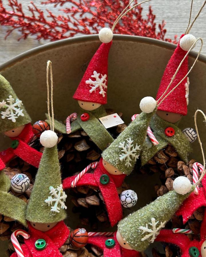 Green and red felt pinecone elf ornaments from @wandsandwillows with glitter snowflakes and candy cane accents for holiday crafts.