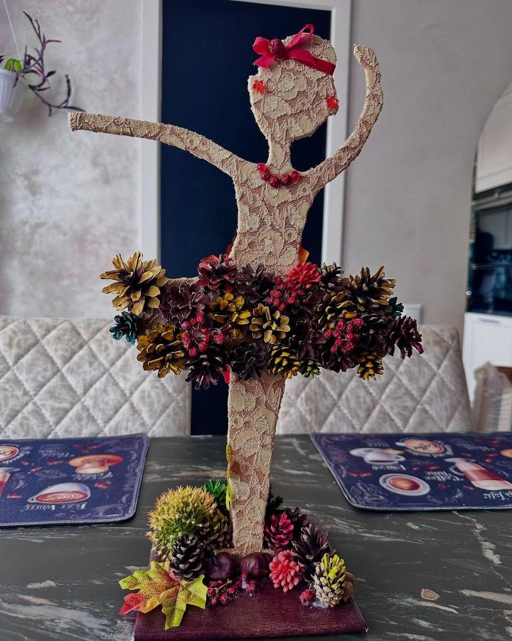 Lace-covered ballerina sculpture with colorful pine cone tutu and red accents from @dubovikmashik. Autumn-inspired nature craft centerpiece.