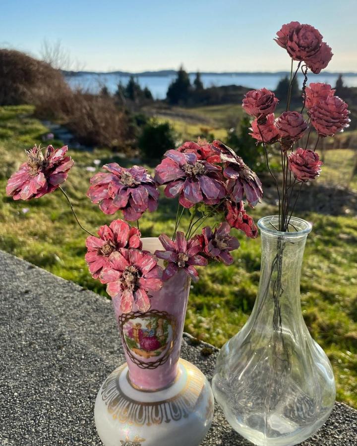 Pink hand-painted pine cone flowers in vintage vases from @floenstyle. Rustic pine cone crafts for adults with delicate wire stems.