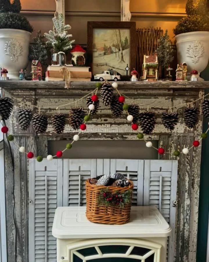 Rustic pine cone garland with red white green felt balls by @franidecor on a vintage mantel, cozy holiday decor idea.