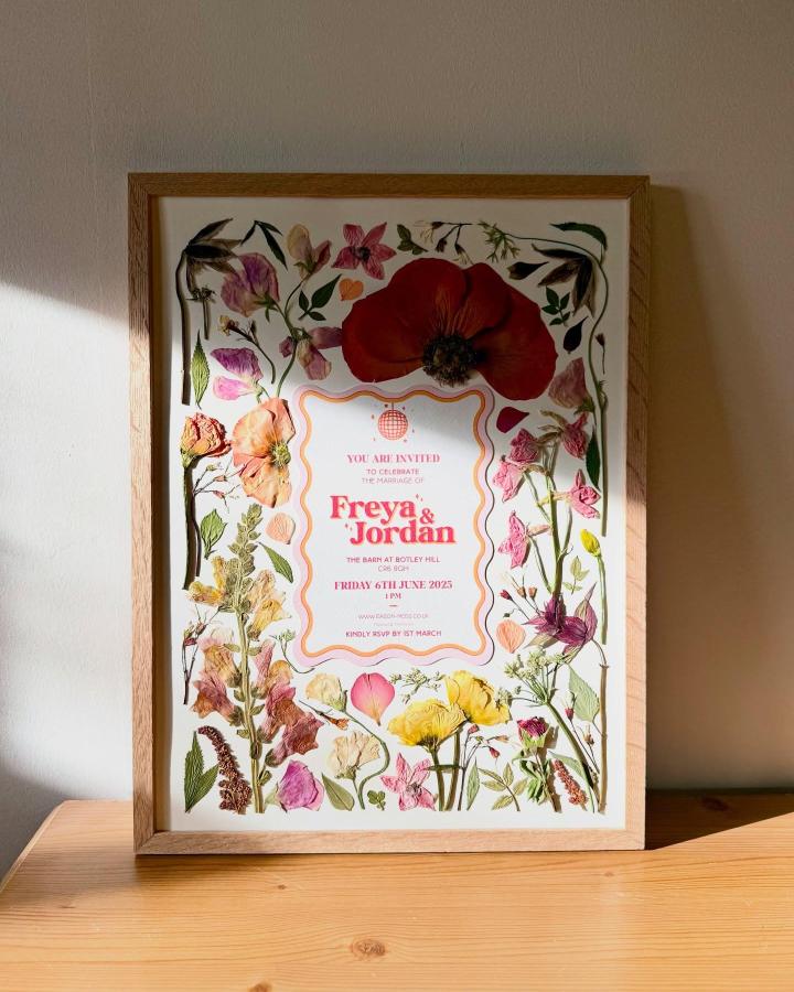 Pressed flower art ideas framed with colorful blooms from @anther_art. Wedding invite art piece with red, pink, yellow flowers and greenery.