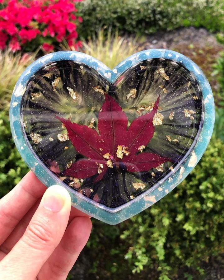 Heart-shaped resin dish with red maple leaf and gold flakes by @juliart84. Handmade nature-inspired keepsake accessory.