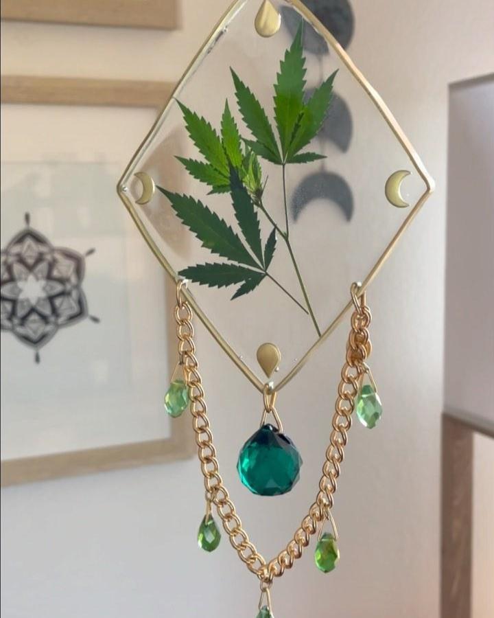Green leaf sun catcher with gold chain and crystal beads from @floraandfoliageco. Transparent glass frame with botanical elements and decorative moons.