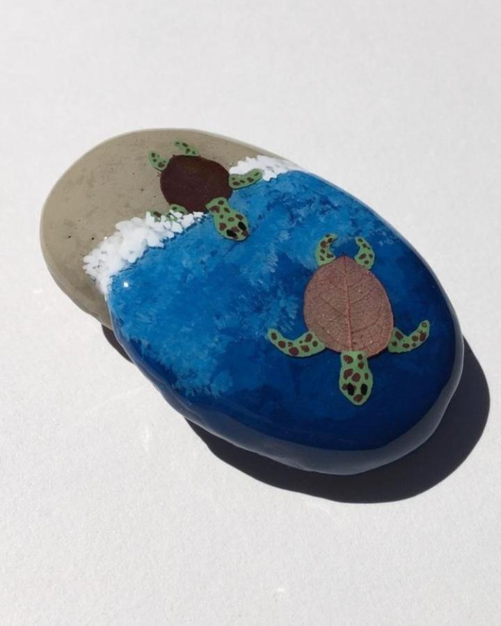 Natural dried leaf turtle shells on hand-painted blue and sand stones by @pressedflowerrocks. Coastal inspired mixed-media craft with textured detail.