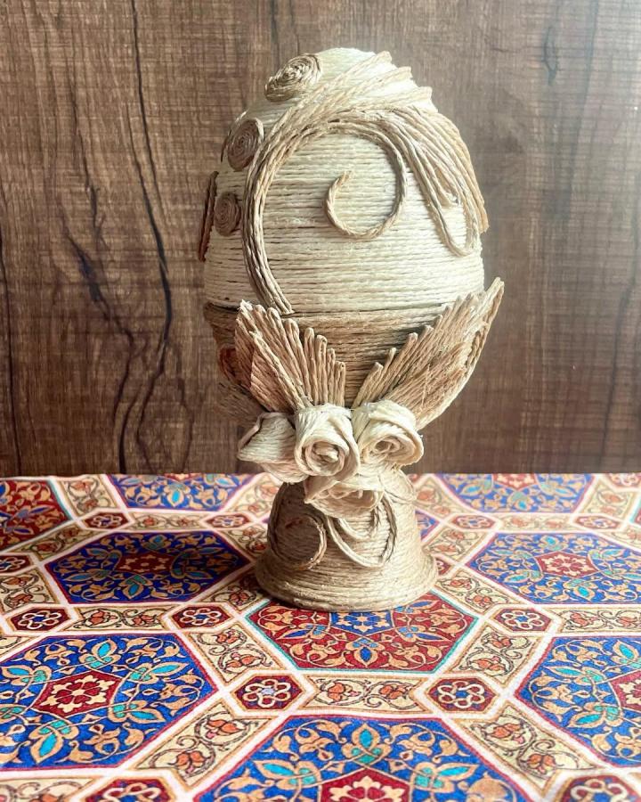 Natural jute fiber Easter egg handcrafted tabletop decor from @artisanat_1920 with delicate rope floral details.