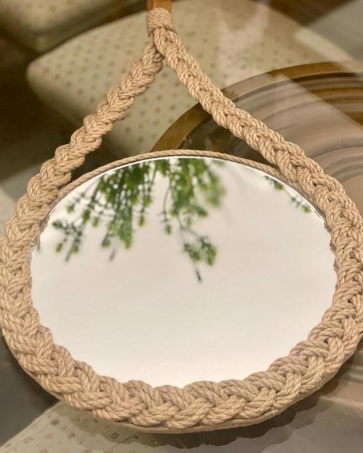 Natural braided jute rope mirror from @nayahomedecor showcasing cozy and earthy rope decor ideas with a looped hanging design.