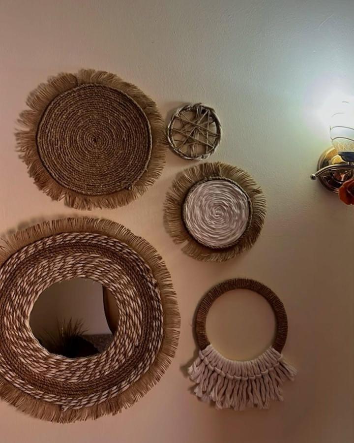 Natural earthy woven fiber wall hangings from @hands.eg_. Handmade circles with fringed edges adding rustic charm.