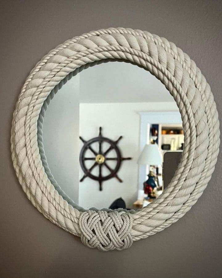 Creamy white nautical rope mirror frame from @beaglebayknots featuring coastal rope decor ideas and intricate knot detail.