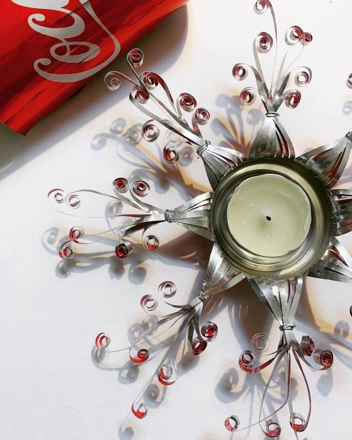 Red and silver upcycled Coca-Cola can tea light holder by @kan_i_kare featuring curled metal strips creating floral designs.
