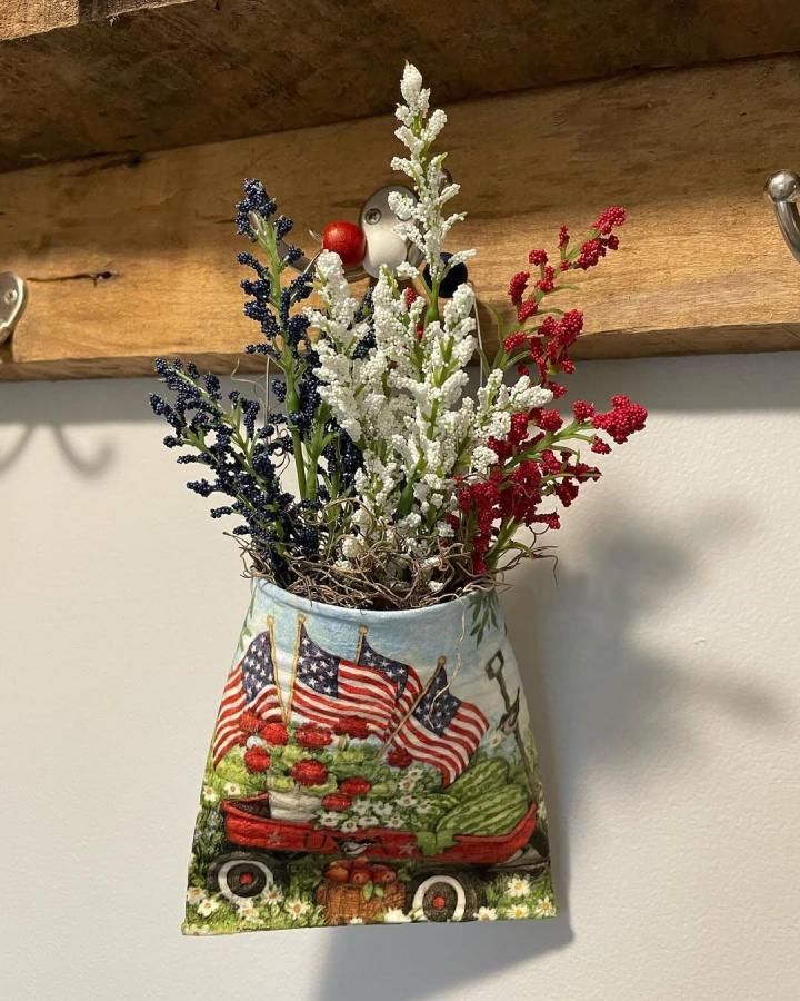 Patriotic vintage wagon decorated hanging container from @kristyskrafts2 with red white and blue faux flowers inside.