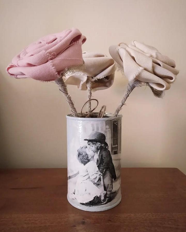 Soft pink and cream fabric roses in a vintage photo-decorated tin can from @myrtines_ showing charming handcrafted tin can crafts.
