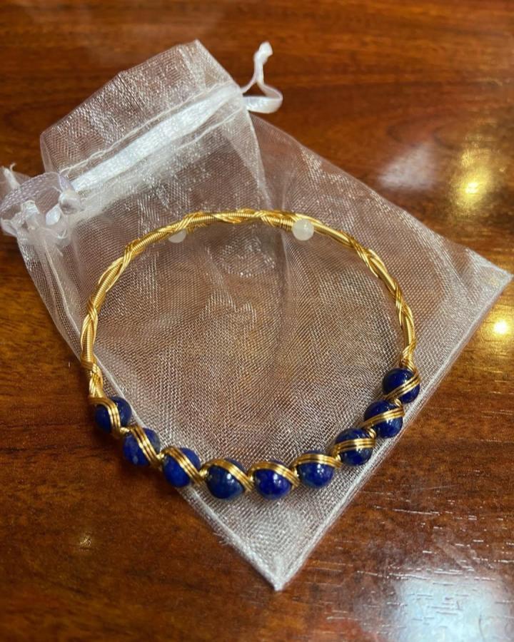 Gold twisted wire bracelet with wrapped dark blue beads from @iprefermagneto. Stylish and delicate wire jewelry ideas in close-up.
