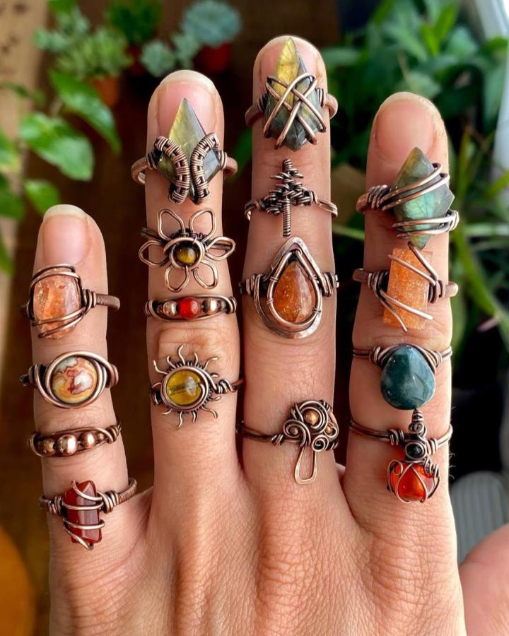 Copper wire rings with earthy stones on fingers from @abbeyroadcollection. Unique handcrafted gemstone and wire wrapping designs.