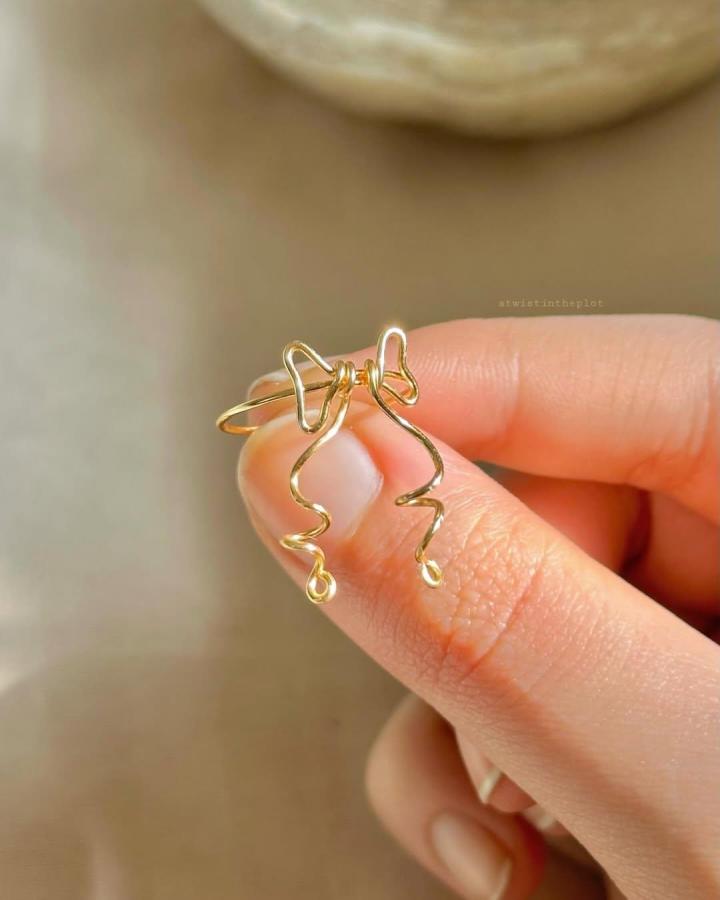 Gold wire handcrafted jewelry piece from @atwistintheplot showing abstract curved shapes perfect for handmade jewelry crafts.