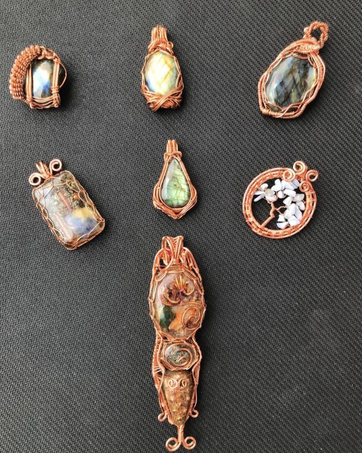 Copper wire wrapped gemstone pendants by @dimebag_dave featuring labradorite and jasper stones with intricate coil details on dark fabric background.