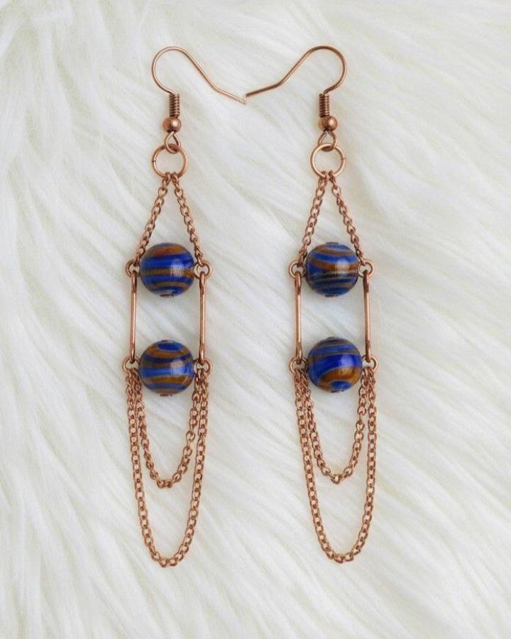 Copper wire earrings with blue and brown beads from @nidhisurana20. Delicate chain details complement wire jewelry ideas beautifully.