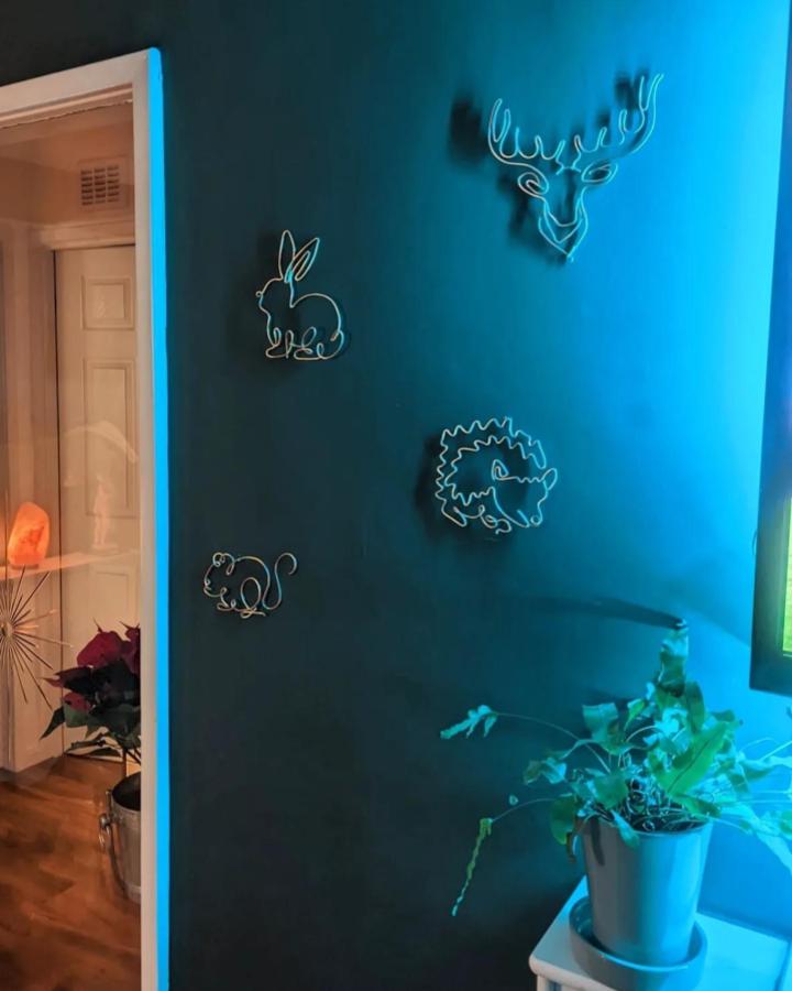 White wire animal silhouettes on a dark teal wall from @thewireflamingo feature charming wire wall art ideas with playful woodland shapes.
