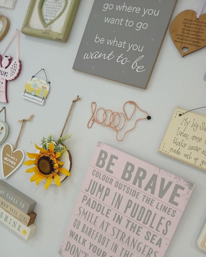 Copper wire dog silhouette art hanging on pastel wall with mixed vintage and inspirational home decor by @wirefoxliverpool. Playful metal craft with warm tones.