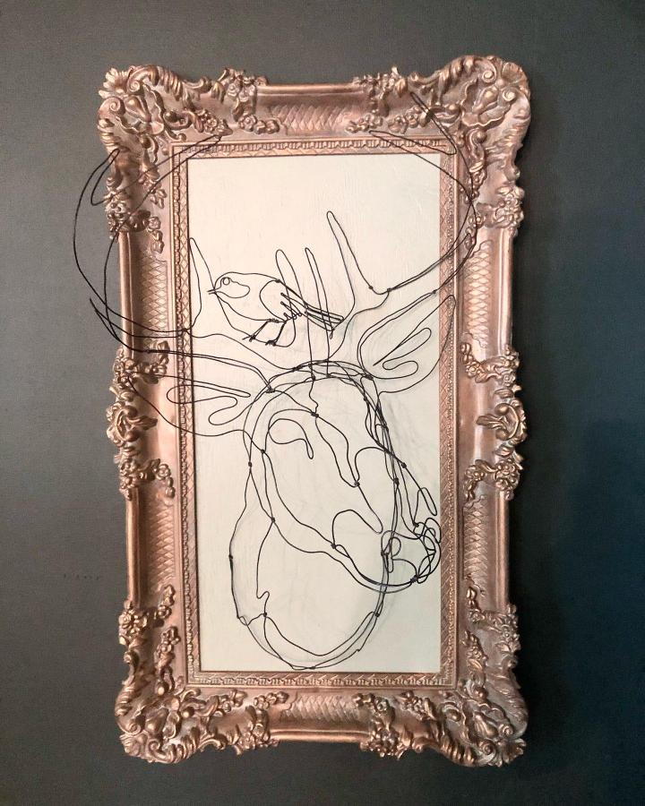 Black wire deer and bird silhouette framed in ornate rose gold frame by @rasor_made. Handmade fine line wire sculpture blending vintage decor and minimalism.
