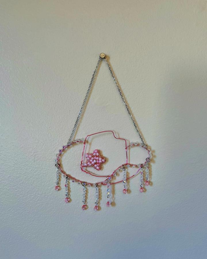 Pink wire fish wall art with dangling bead chains from @hannachristine_creates shows charming wire wall art ideas with delicate beading and playful design.