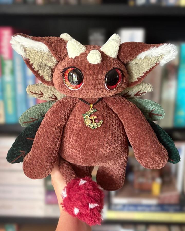 Brown plush stuffed woodland creature with cream accents and a red spotted tail by @the.yarn.gremlin. Soft, textured handmade craft inspired by forest animals.