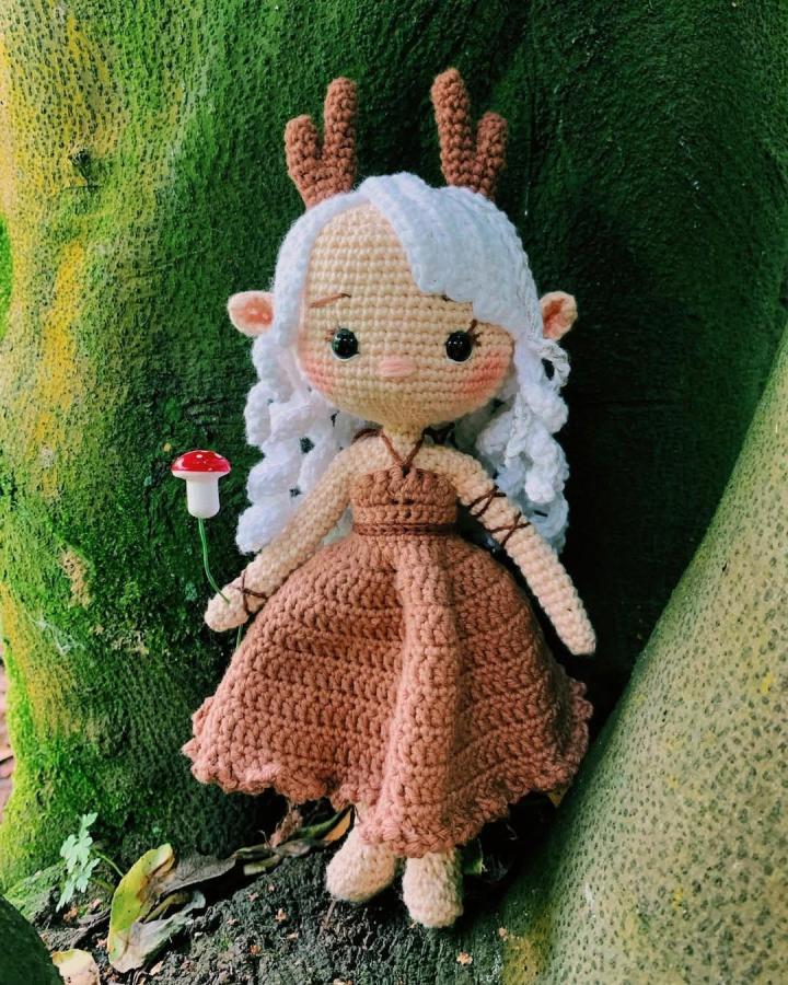 Caramel yarn crochet doll with white curly hair and deer antlers from @freyfrey_crochet. Whimsical forest-themed amigurumi design.