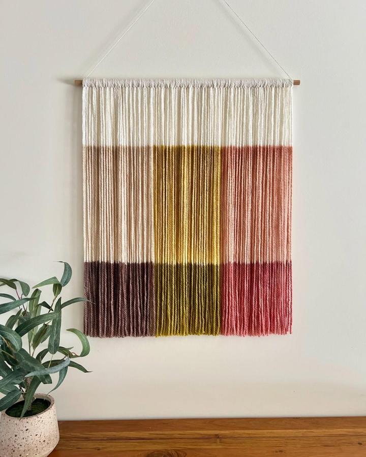 Off-white caramel mustard and brick yarn wall hanging with vertical color blocks by @wallflowers_hangingart. Cozy textured fiber art for modern walls.