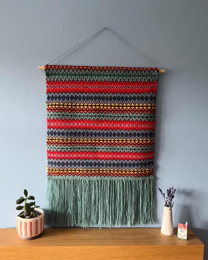 Olive green red gray mustard woven wall hanging from @ditzy.and.dotty with fringe detail creating a cozy artistic vibe.