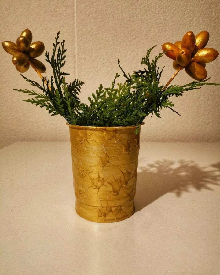 Golden painted acorn flower picks in textured gold cup with greenery from @artsbyblancarosso. Elegant nature-inspired decoration idea.