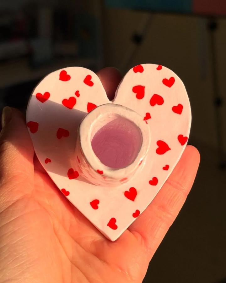 Pink heart-shaped clay candle holder with red hearts by @ranins_art_ featuring playful patterns and smooth finish clay candle holder craft ideas.