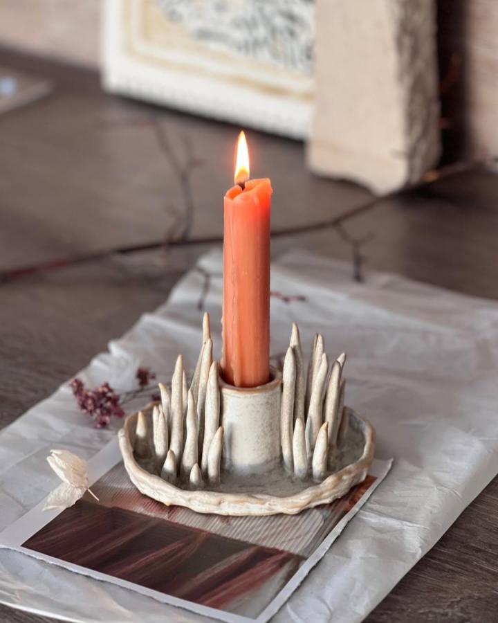 Creamy textured handmade clay candle holder with spiked details by @kee.jann. Rustic, natural-inspired tabletop decor piece.