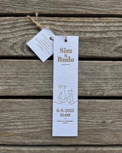 White textured paper wedding invitation with gold foil typography and sketched pets on rustic wood background by @noistypo. Minimalist, charming style.