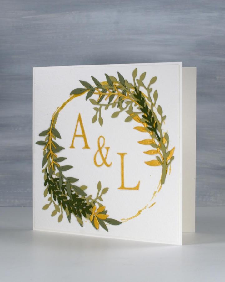 Green and gold leafy wreath monogram diy wedding card ideas from @heather.telford featuring textured die-cut leaves on white cardstock.