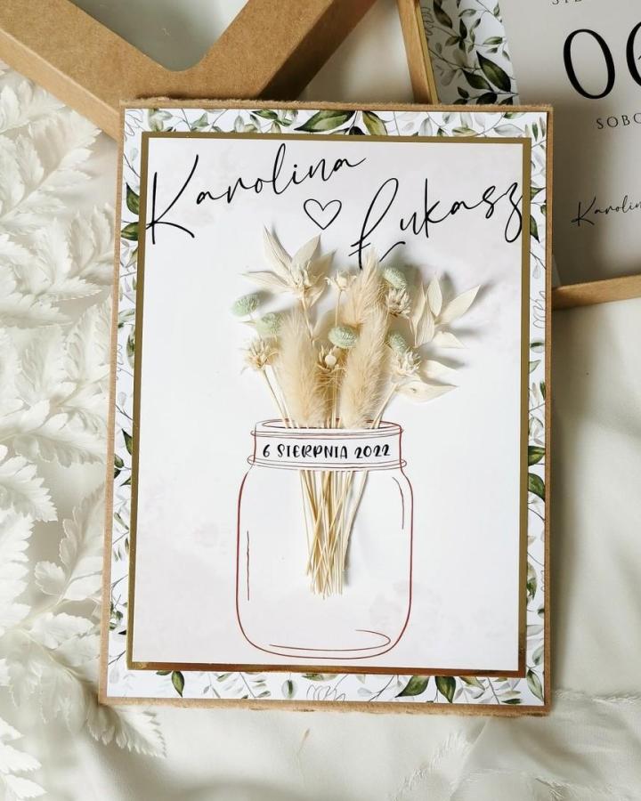 Dried neutral floral bouquet on a white card with mason jar illustration by @larkowezaproszenia, rustic wedding invite craft idea.