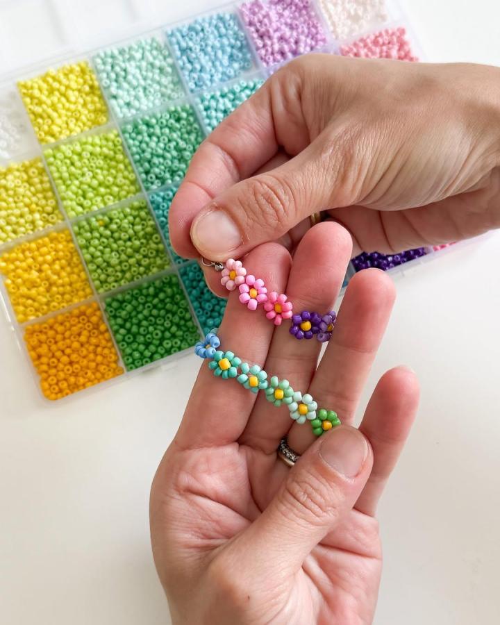 Pastel and bright seed bead flower bracelets from @theimaginery shown in hands with colorful bead organizer for flower crafts for adults.