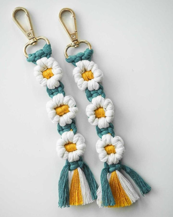 Teal and white cotton macrame keychains with yellow flower centers and tassels by @macramemakersclub. Bright handmade floral accessories.