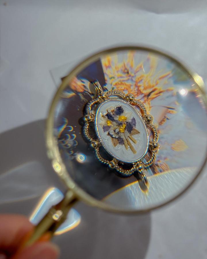Pressed wedding flowers preserved in a vintage style resin pendant from @artlaystudio. Flower crafts for adults capturing natural keepsakes beautifully.