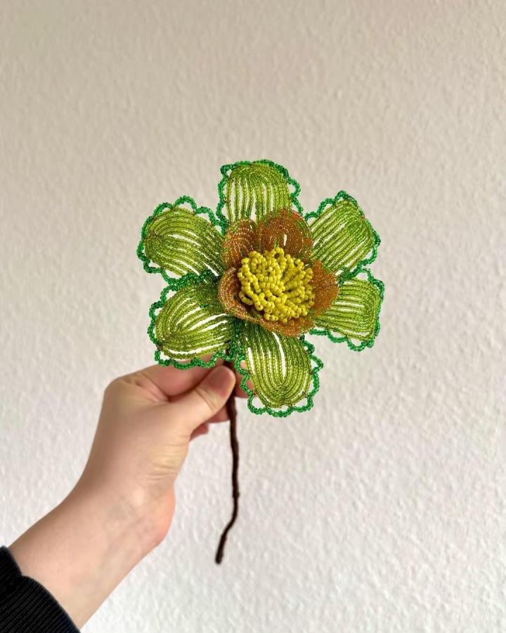 Green and yellow beaded flower craft from @bloom_tales_ showing detailed petals and a textured center, perfect flower crafts for adults.
