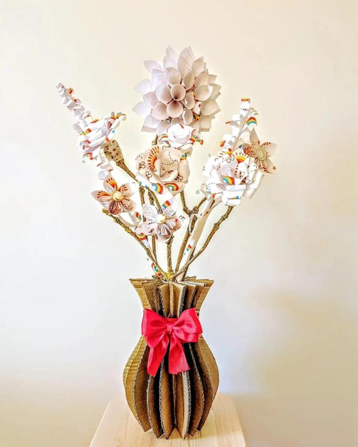 Whimsical pastel paper flower bouquet in a pleated cardboard vase with red bow by @theclanmurray flower crafts for adults bright and creative arrangement.