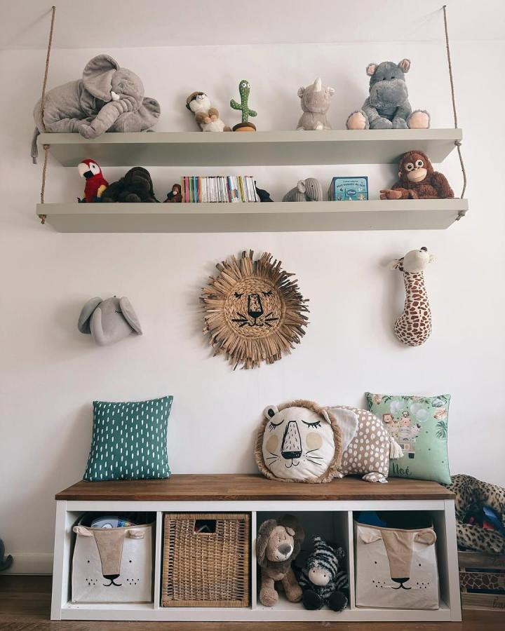 Beige and white storage bench with wooden top and animal-themed bins in kids room by @bricodeconono playful and organized seating area