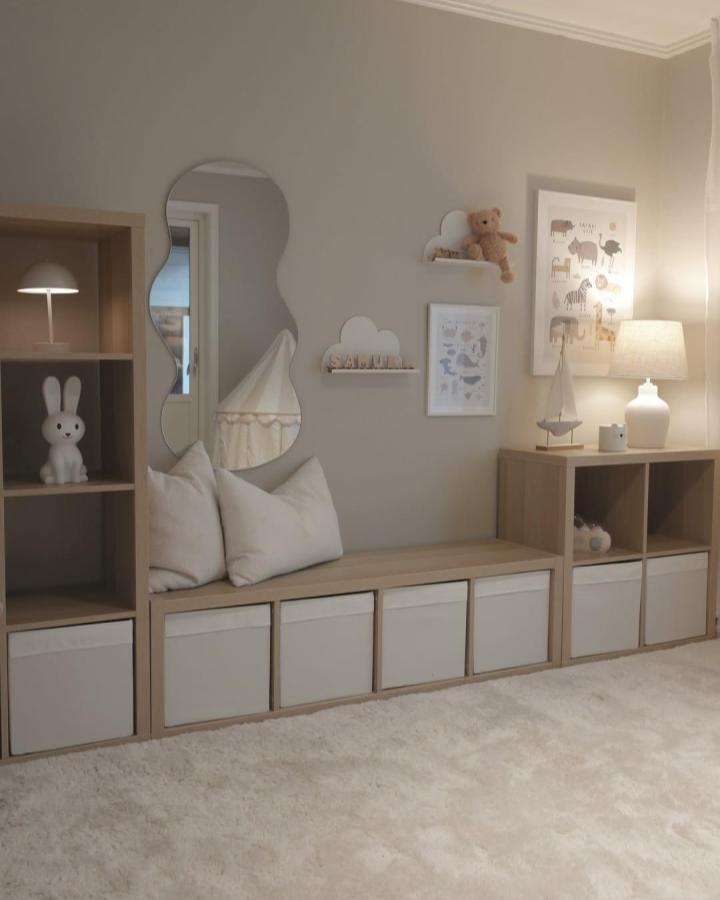 Neutral wood and cream fabric storage bench with cushions and playful wall decor by @mariav.interior Soft, inviting kids room seating and storage solution.