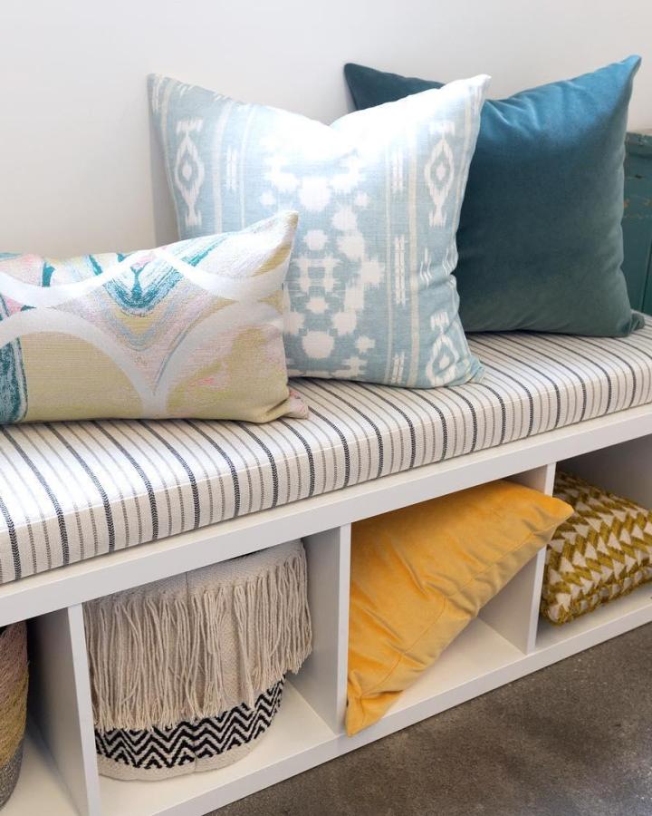 Striped cushioned ikea kallax bench ideas by @tonicliving with cozy pillows and storage cubbies underneath.