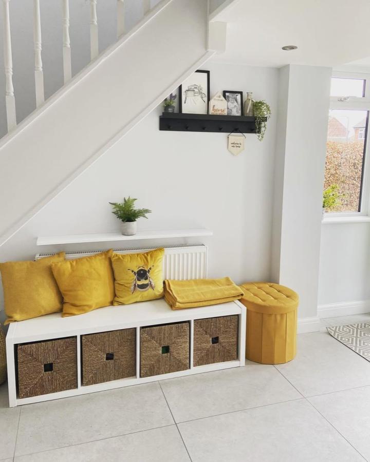 White Kallax bench with woven baskets and bright yellow cushions from @home_round_the_croft. Cozy, organized seating solution for entryway.