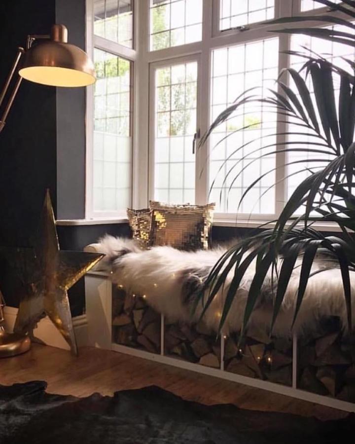 White built-in style window seat with wood cubby storage and cozy fur throw from @artynads by the window in a modern room.