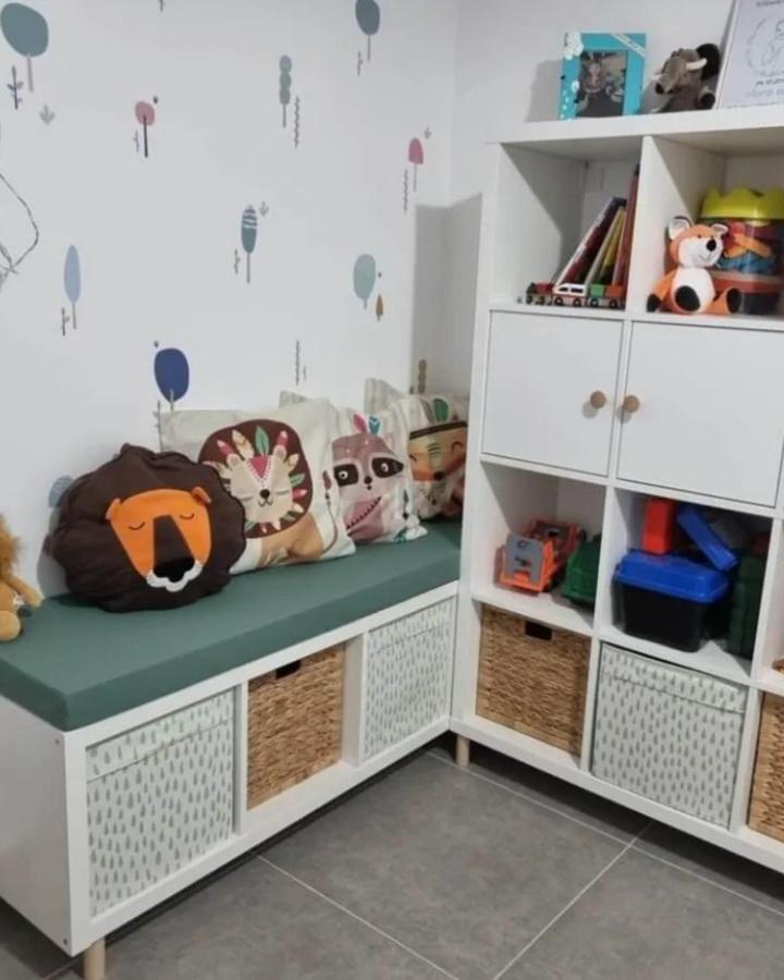 Green cushioned Ikea Kallax bench ideas with animal pillows and mixed baskets by @myprecious.il in a cozy kids’ room corner.