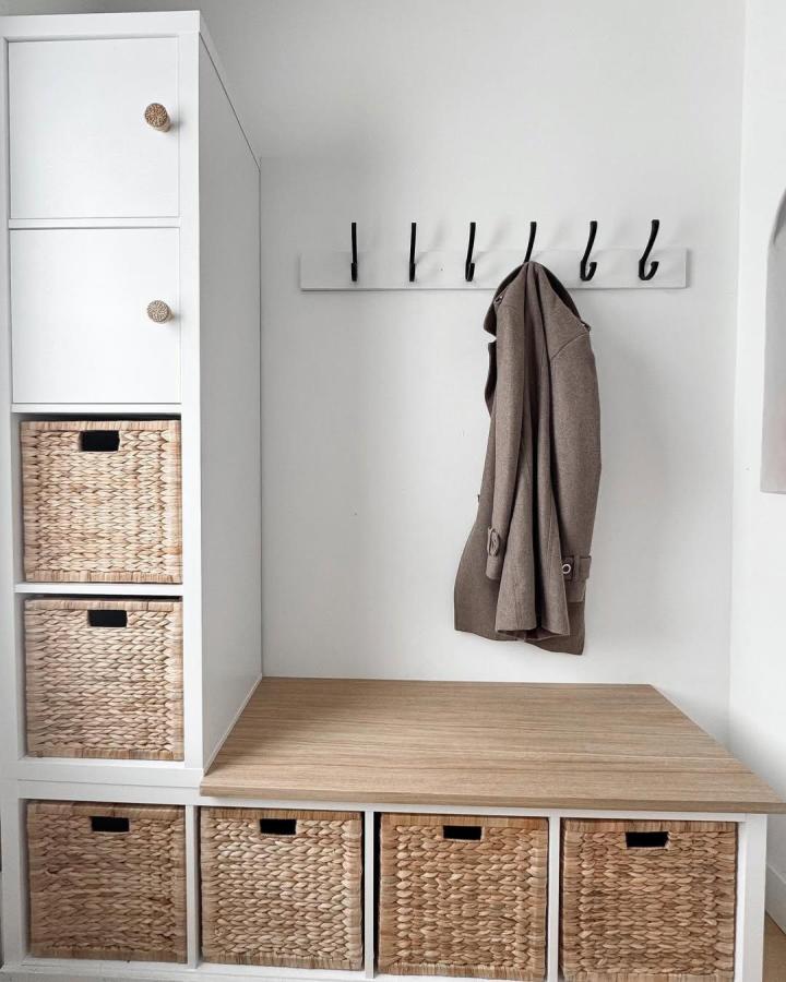 Natural woven basket entryway bench from @jghalebxo with wooden top and white frame storage seating combo. Simple sophisticated design.