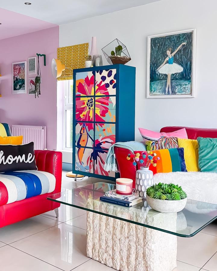 Bright colorful floral door-covered cabinet with deep blue frame in living room by @hilaryscolourfulhome. Artistic and vibrant furniture transformation.