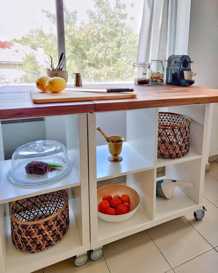 White Ikea Kallax kitchen island hack with wooden top and open cubbies on wheels by @_craftydust. Stylish, movable kitchen storage unit.