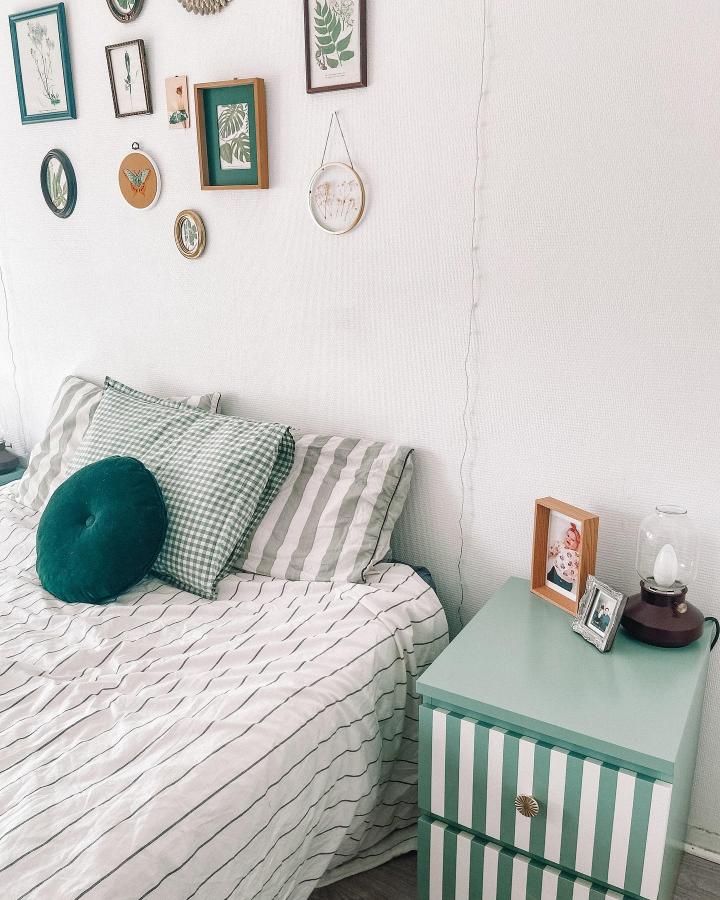 Mint green and white striped Ikea Malm dresser hacks bedside table styled by @maatrez in cozy bedroom corner.